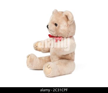 small brown teddy bear sits on a white isolated background, funny children`s toy Stock Photo